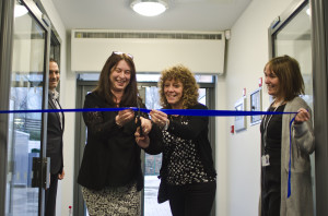 Bilingual Primary School founder and chair of governors Marina Gutierrez cuts a ribbon at entrance of the school's new premises, helped by teaching assistant Katherine Davies and watched by fellow founding governor Javier Ruiz and head teacher Wendy King